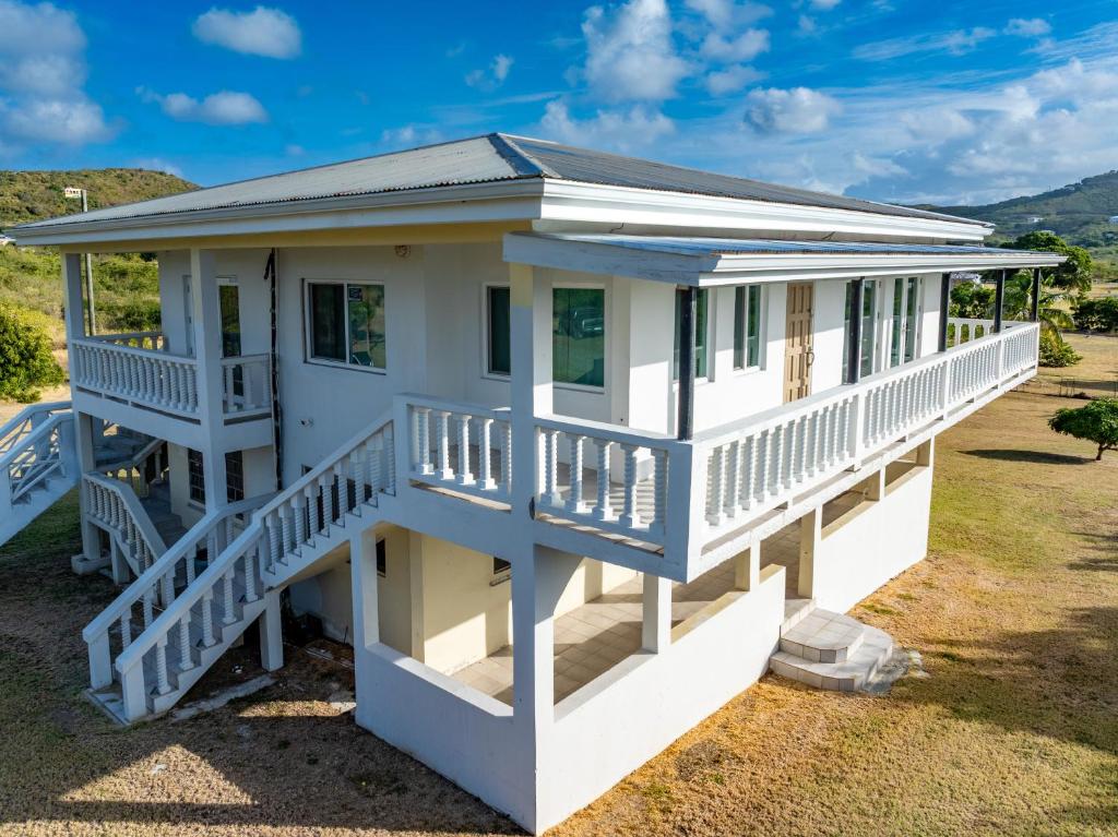 a white house with a large front porch at Southside Serenity of St Croix in Christiansted