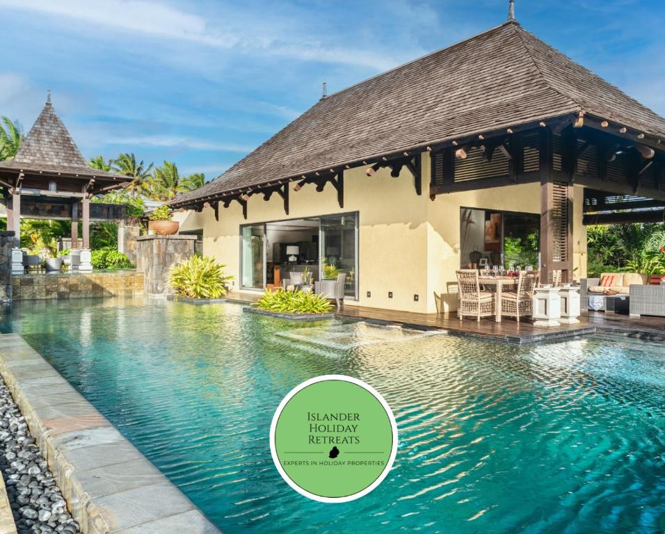 a villa with a swimming pool with a sign that reads master retreat resort at Villa Belle Rive in Bel Ombre