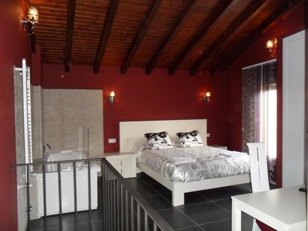 a bedroom with a bed in a red wall at Baelo Claudia in Navalguijo