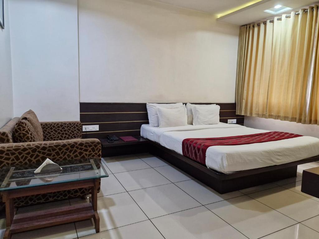 a hotel room with a bed and a couch at Hotel Radiant Kolhapur in Kolhapur