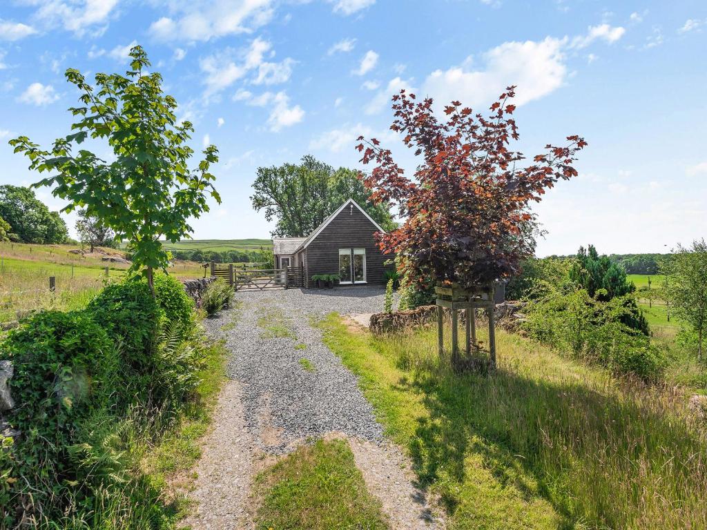 a gravel road leading to a small barn at Strathmaddie Farm Cottage in Palnure