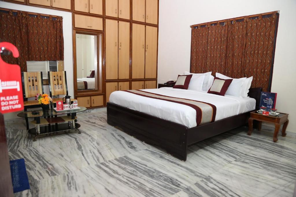 a hotel room with a large bed and a mirror at Sudha Grand Guestinn in Nellore