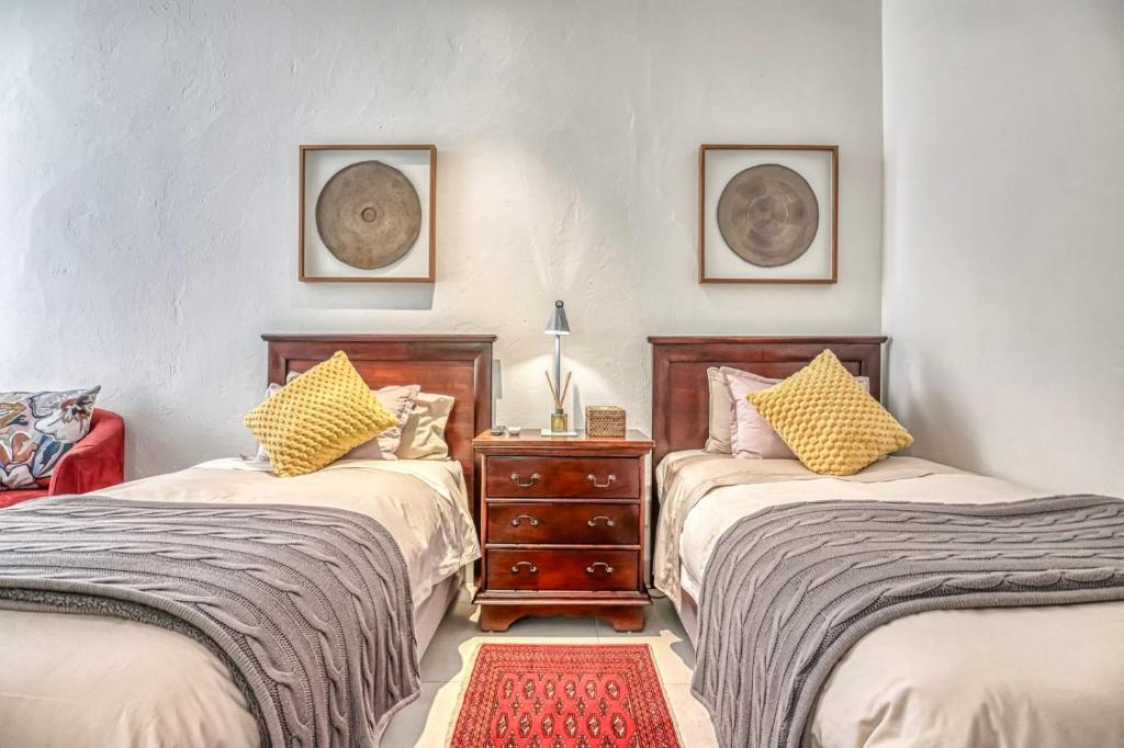 a bedroom with two beds and a nightstand between them at French Bistro Studio in Johannesburg