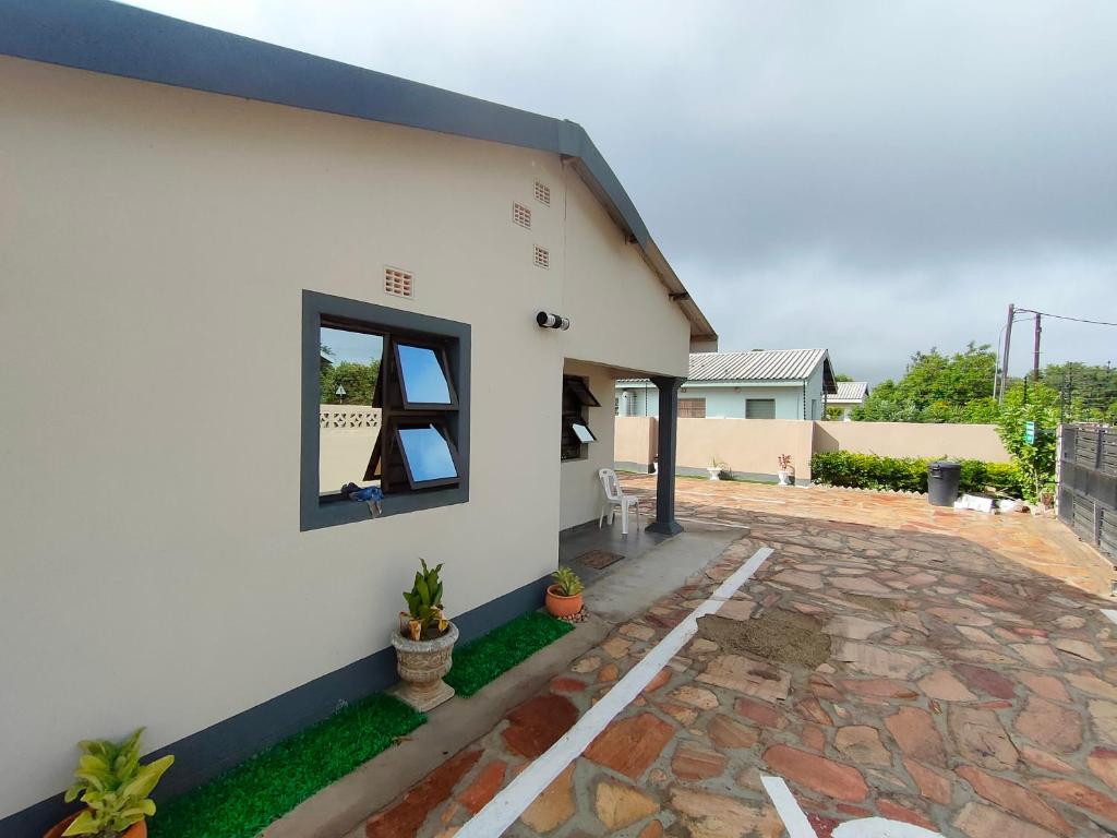 a white house with a window on the side of it at Oloks Guest Inn in Francistown