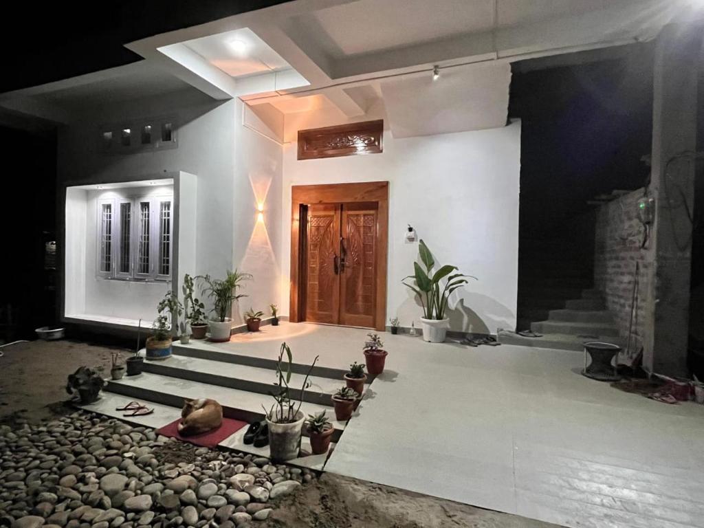a room with potted plants in front of a door at Dharitry Homestay Majuli in Mājuli Island