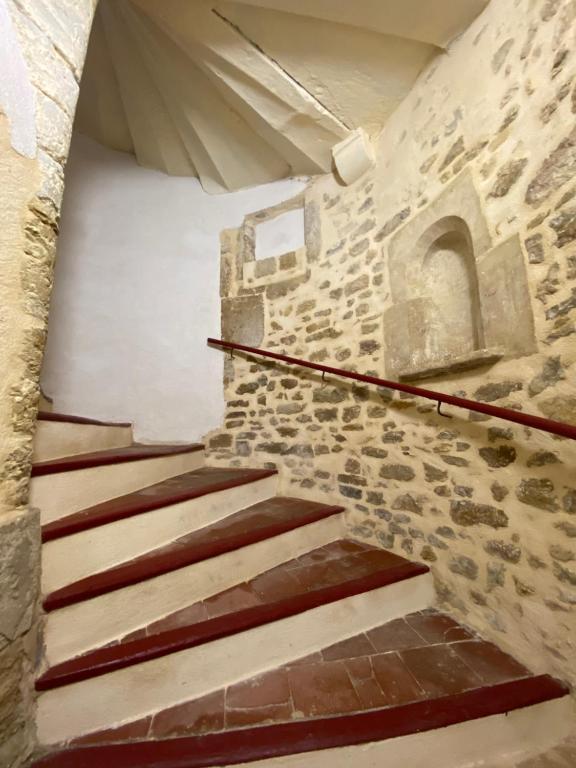 a staircase in a building with a stone wall at Le Cocon de Langes in Orange