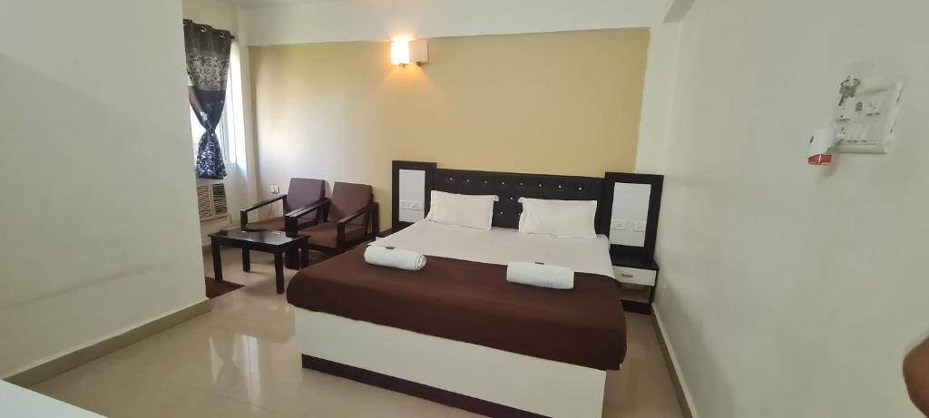 a bedroom with a bed and a table and chairs at Hotel City Garden in Madgaon