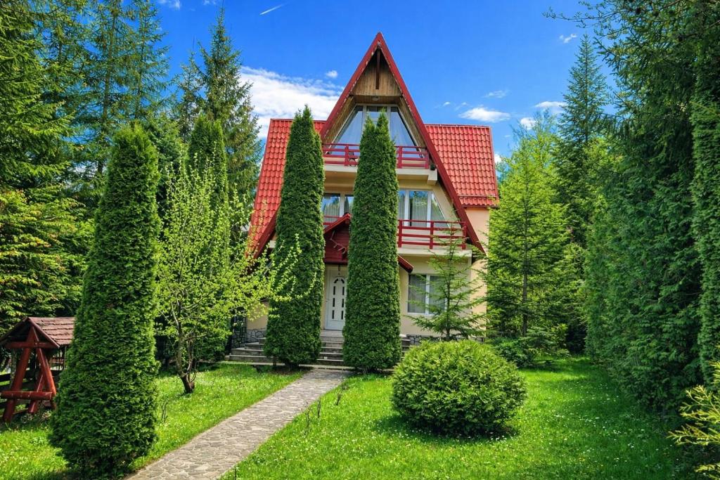 a house with a red roof and some trees at FLH - Emprin House in Predeal