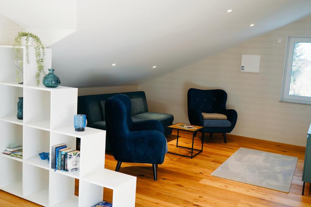 a living room with two chairs and a book shelf at Ferienhaus DONAUzeit in Sigmaringen