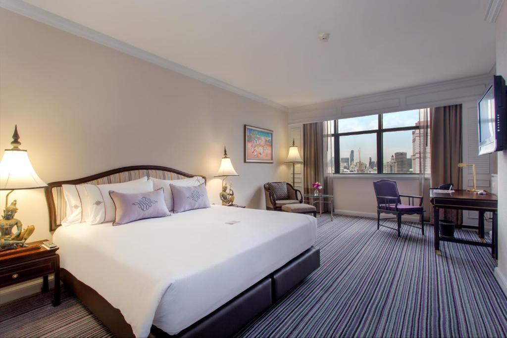 سرير أو أسرّة في غرفة في The Sukosol Hotel