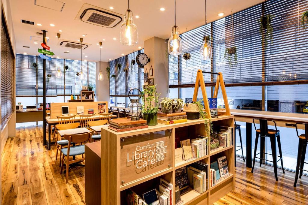 a library with a library cafe with tables and chairs at Comfort Hotel Tokyo Kanda in Tokyo