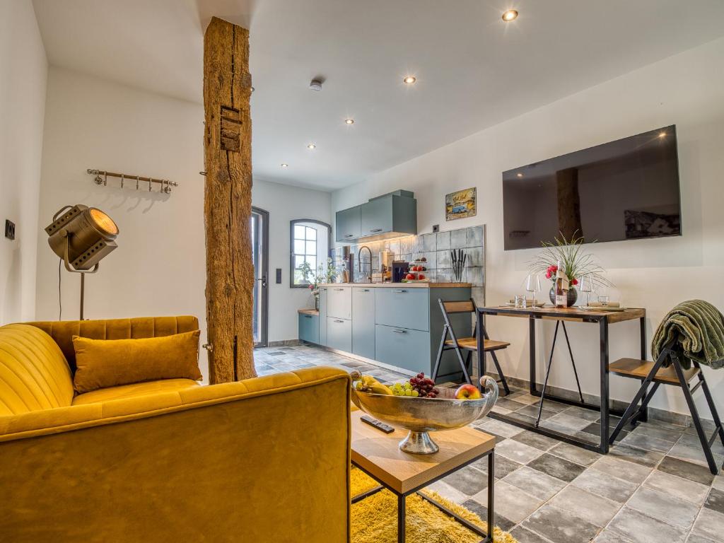 a living room with a yellow couch and a kitchen at Country Lodge - Heuboden in Tating