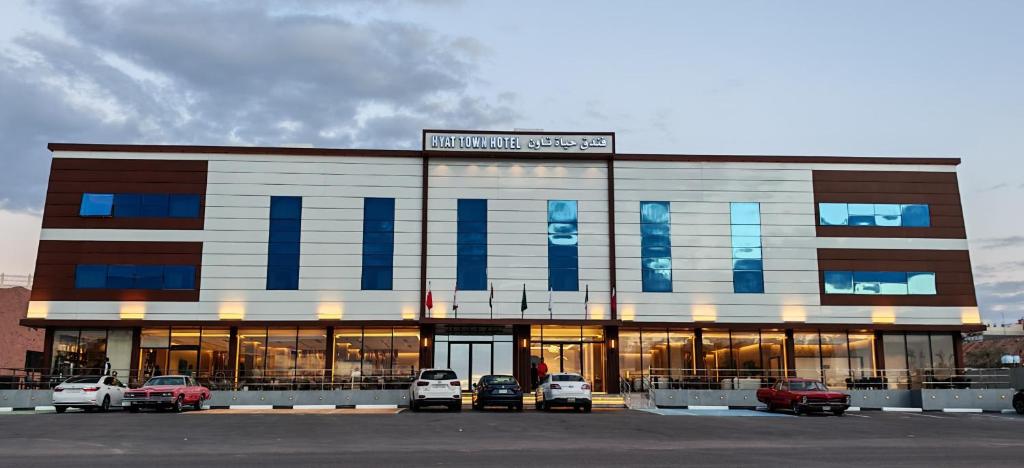 a building with cars parked in a parking lot at فندق حياة تاون حقل in Ḩaql