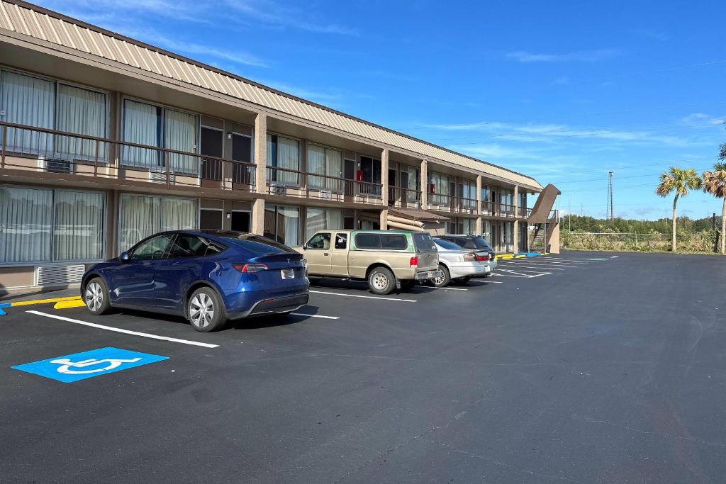 a parking lot with cars parked in front of a hotel at Rodeway Inn Bushnell in Bushnell