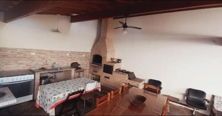 a living room with a table and a brick wall at Edicula Paz e Amor in Piracicaba