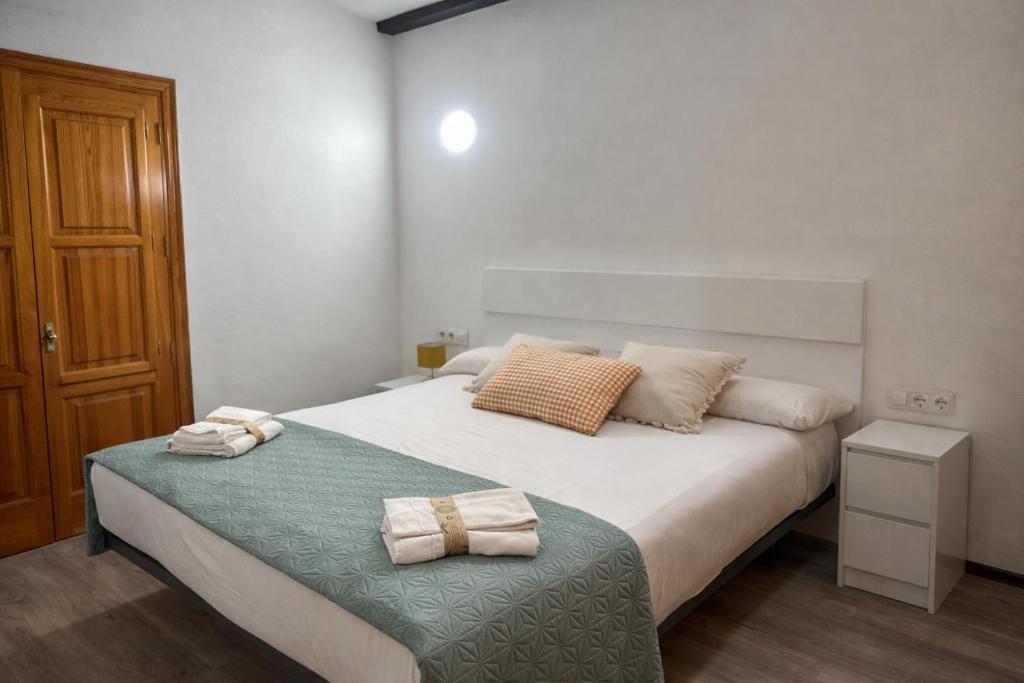 a bedroom with a bed with two towels on it at Mini Peixcateria B in Sagunto