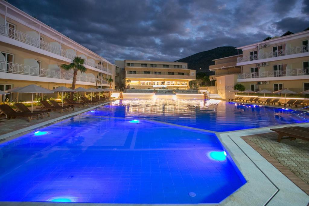 a large swimming pool in a hotel at night at SunBay Hotel in Hersonissos