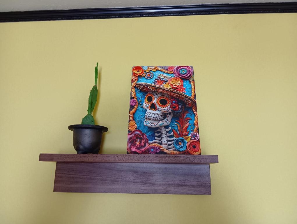 a painting of a skull on a shelf with a plant at HOTEL Saboten Apartment in Miyoshi