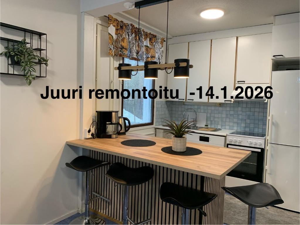a kitchen with a counter with stools around it at Tilava 2mh rivitalo saunalla in Oulu