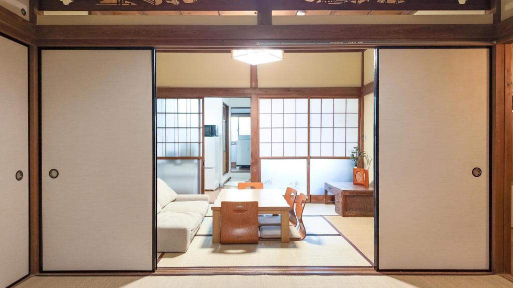 a living room with sliding doors and a table at FUNAKATA MINA House in Tateyama