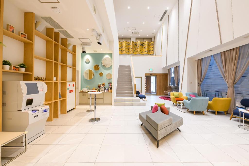 a living room with a couch and chairs and a tv at Hotel Sobial Namba Daikokucho in Osaka