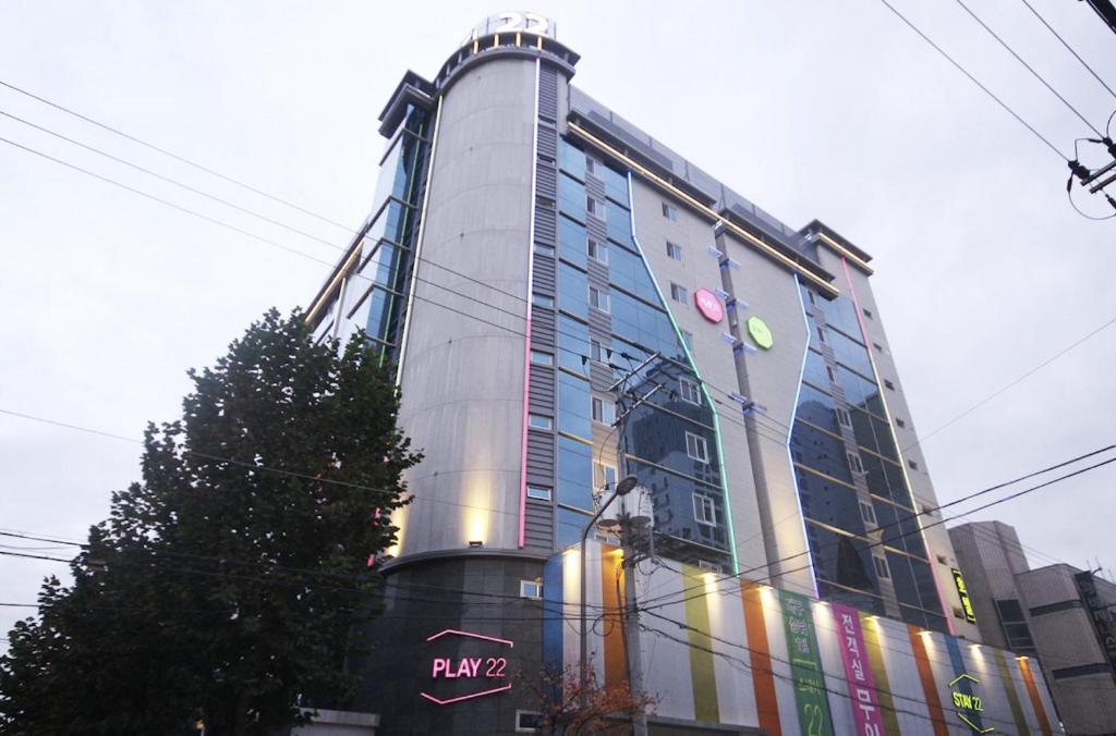 a tall building with a sign on the side of it at Daegu Play and Stay Hotel in Daegu