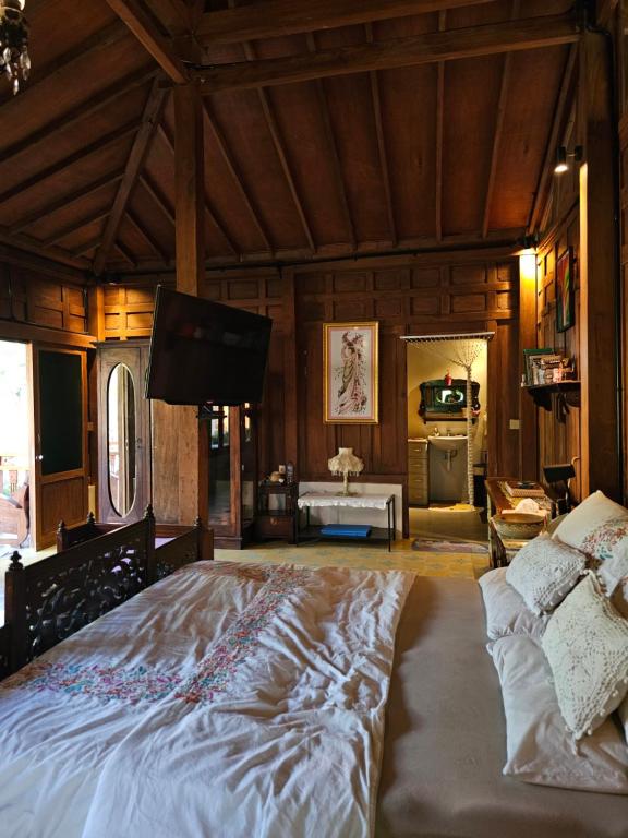 a large bedroom with a large bed and a television at Sembung Healing House in Sangeh