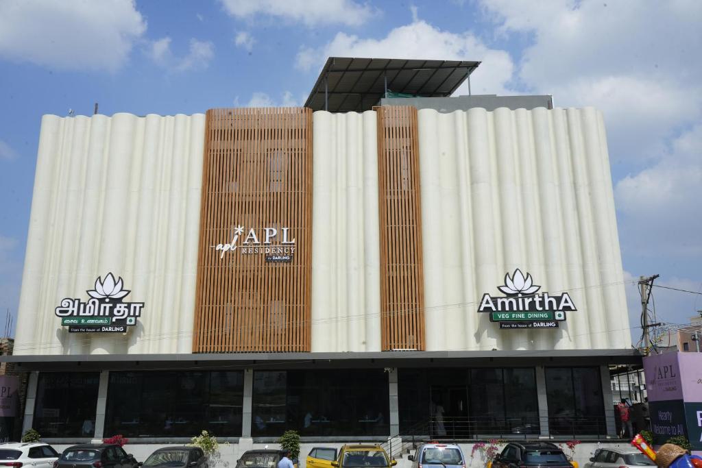 a large building with cars parked in front of it at APL Residency by Darling in Vishāram