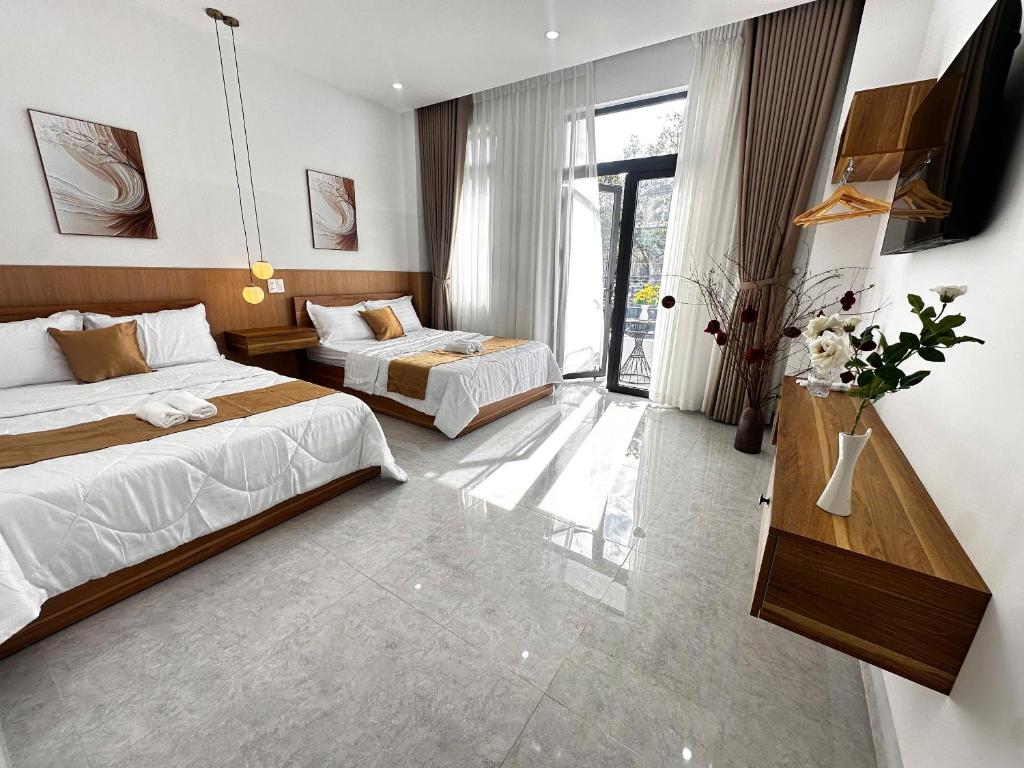 a hotel room with two beds and a television at Mai Phương Motel in Pleiku