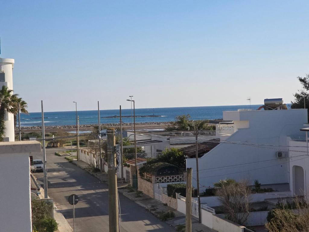 a view of a street with the ocean in the background at Bilocale zona spiaggia Home Salento com in Torre San Giovanni Ugento
