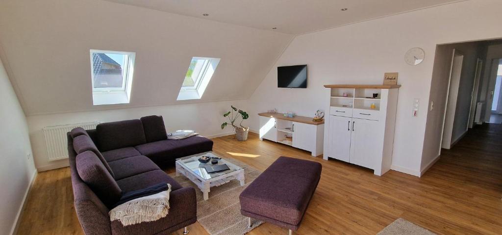 a living room with a couch and a table at Ferienhaus Strandallee 10a in Burhave