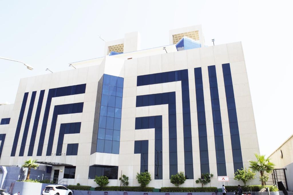 um edifício com riscas azuis e brancas em Ottoman Signature Hotel em Al Khobar