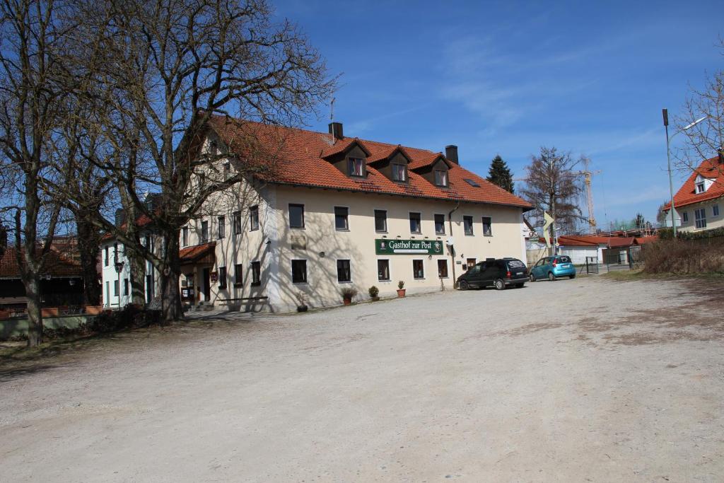 ein großes weißes Gebäude mit rotem Dach in der Unterkunft Gasthof Zur Post in Schwabhausen bei Dachau
