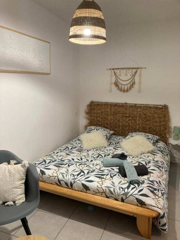 a bedroom with a bed and a chair at Appartement cosy centre du Crès in Le Crès