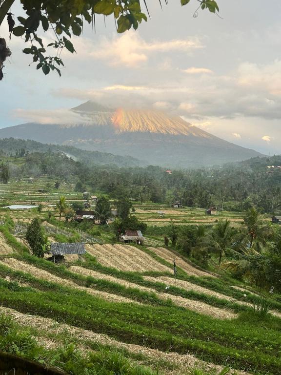 a mountain in the distance with a rainbow in the sky at Panorama Sidemen in Silebeng