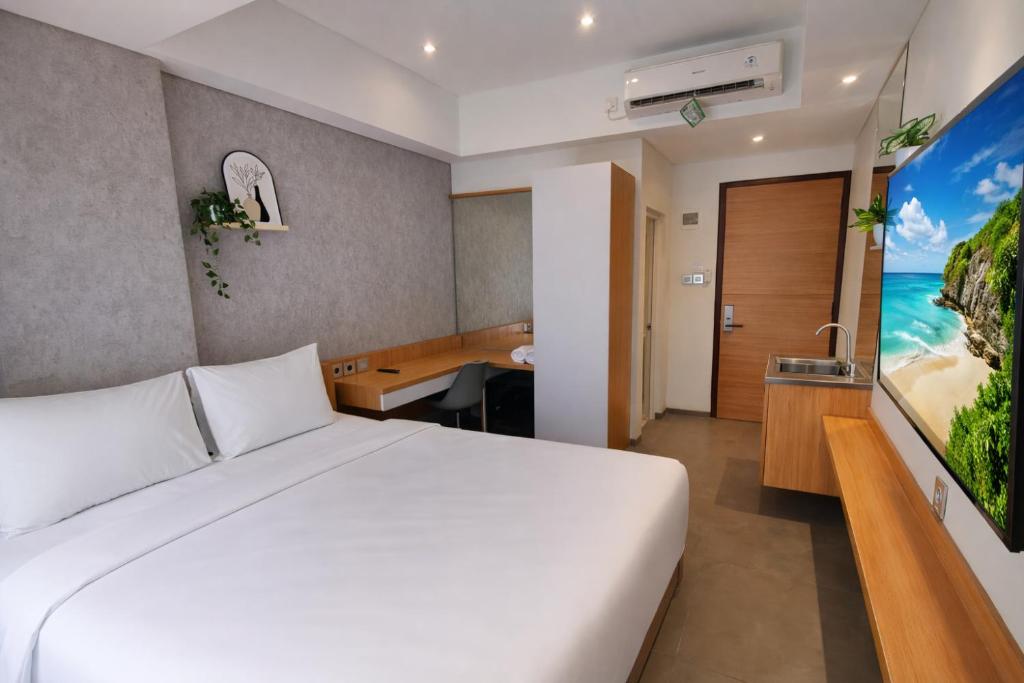 a hotel room with a bed and a bathroom at The Orchid by FLAT06 in Jakarta