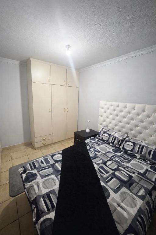 a bedroom with a large bed with a large headboard at PrimeStay One 2 Bedroom Apartment in Johannesburg