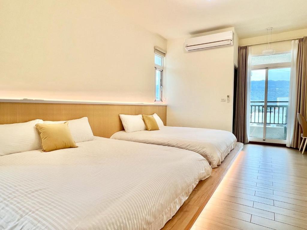 two beds in a room with a window at Bird Walking in Yuli