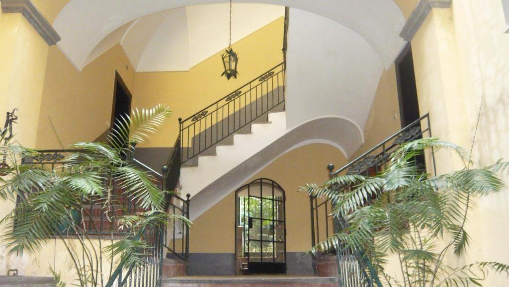 a building with a staircase and some palm trees at 1878 Sorrento Guest House in Sorrento