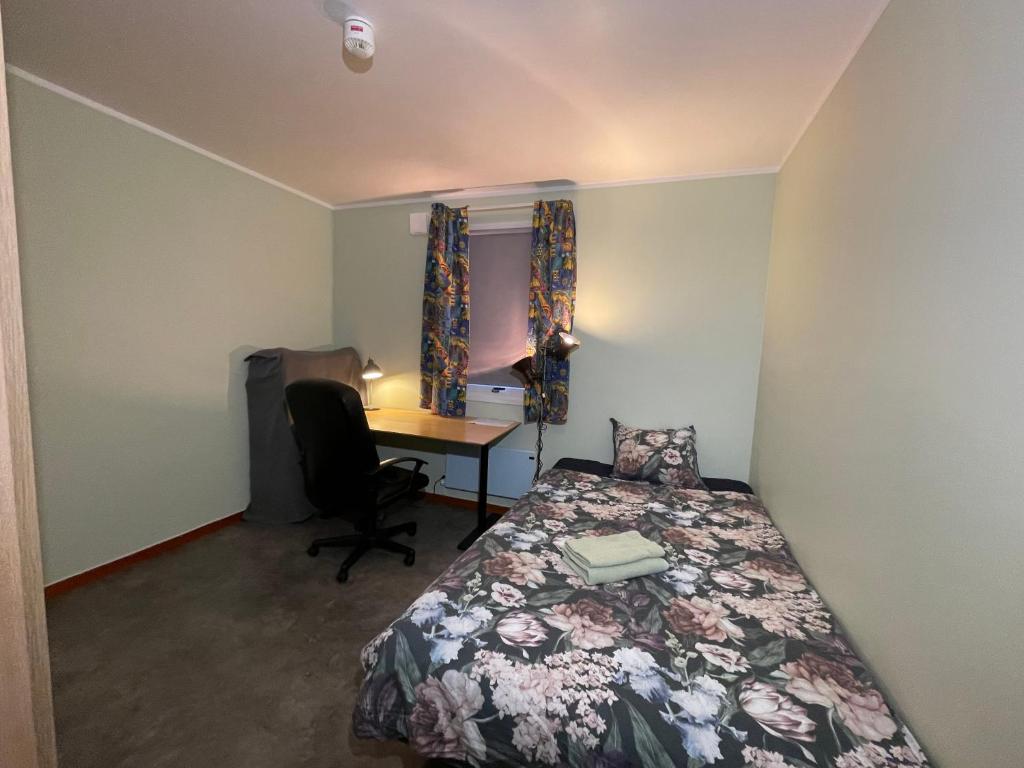 a small bedroom with a bed and a desk at Laplanders room 15 in Kiruna