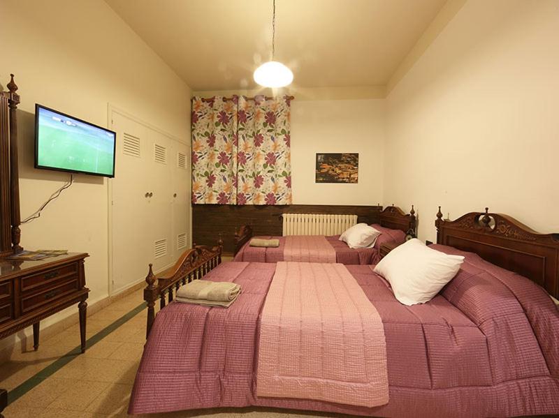 a bedroom with two beds and a flat screen tv at Beit Wadih in Ghazīr