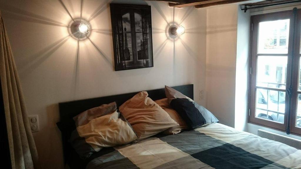 A bed or beds in a room at The Pearl of Marais