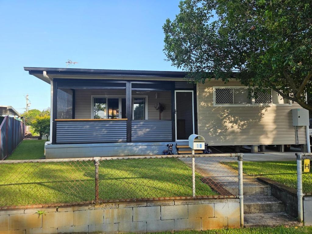 a house with a fence in front of a yard at Bongaree Beach Shack - close to the bridge! in Bongaree