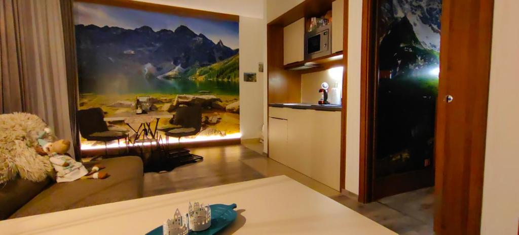 a living room with a large painting on the wall at Apartment FIMM in Veľká Lomnica