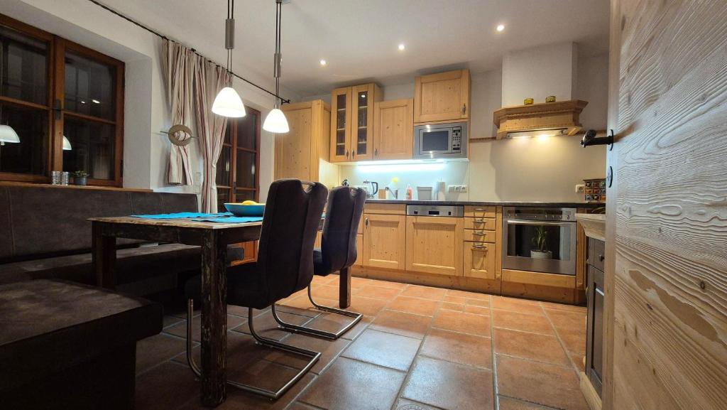a kitchen with a table and some chairs in it at Ferienwohnung beim Schnellerbauer in Micheldorf in Oberösterreich