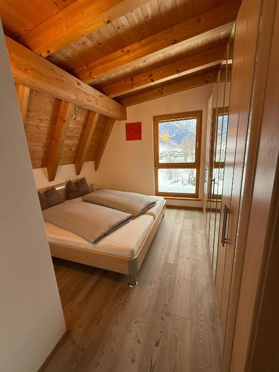 a bedroom with a bed in a room with wooden ceilings at AusZeit in Gschnitz