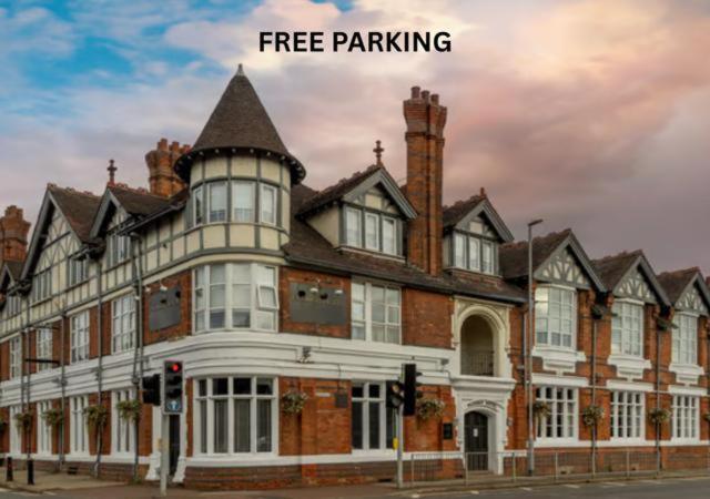 a large building on a street with the words free parking at Best Western The Plough Hotel in Northampton