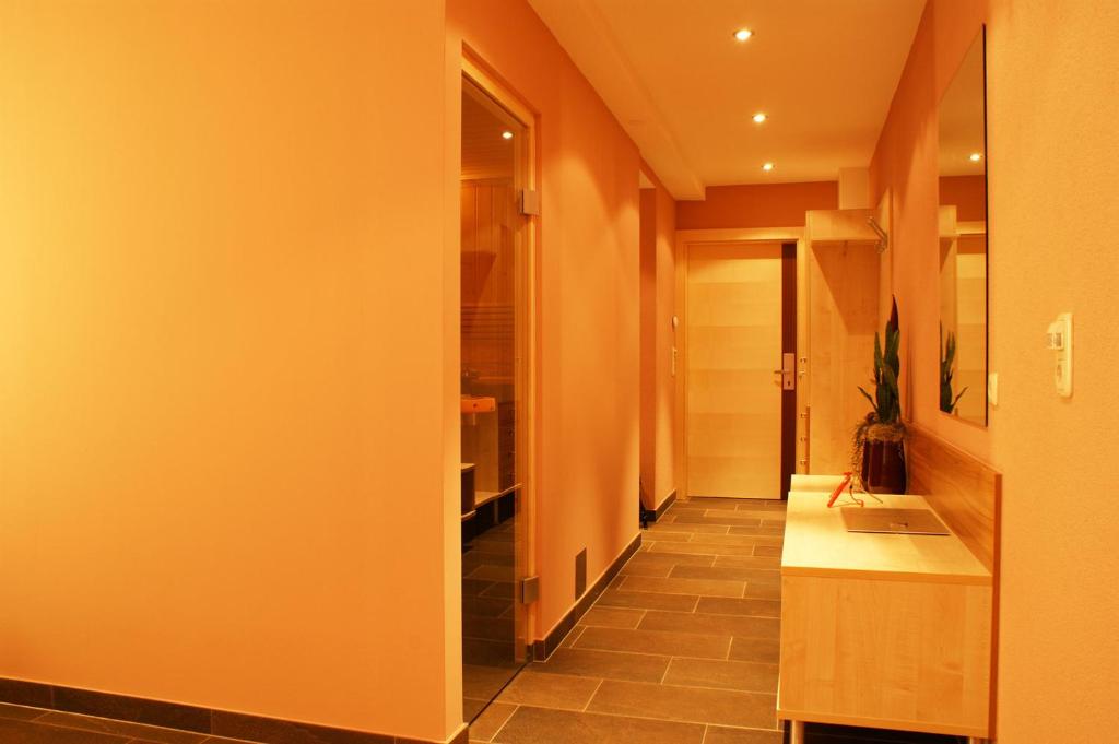 a hallway with a kitchen with orange walls and a counter at Apart Flürs in Flirsch