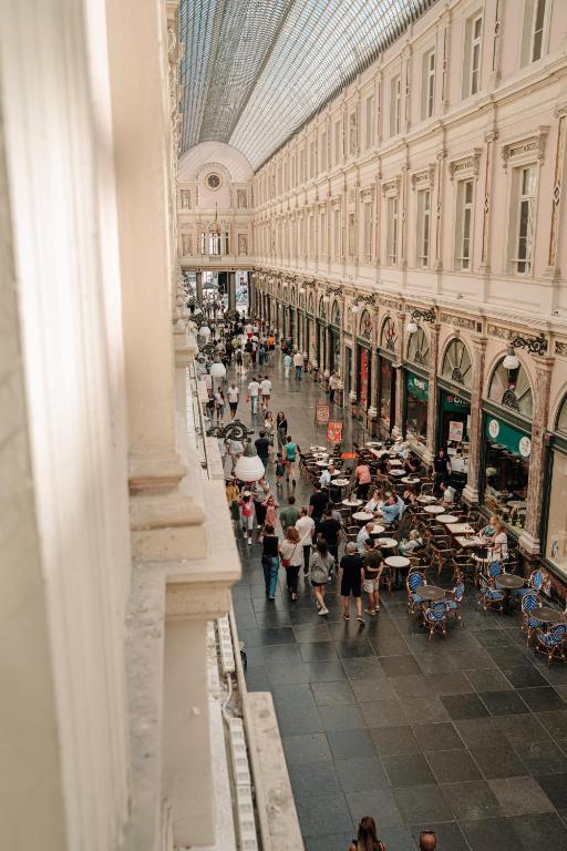 a crowd of people walking through a shopping mall at Les Chambres du Vaudeville in Brussels