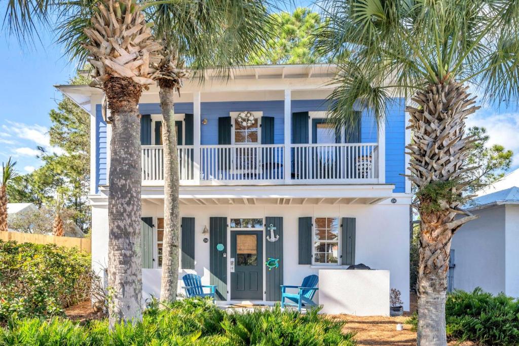 a blue house with palm trees in front of it at Blue Sky Bungalow 156 in Seagrove Beach